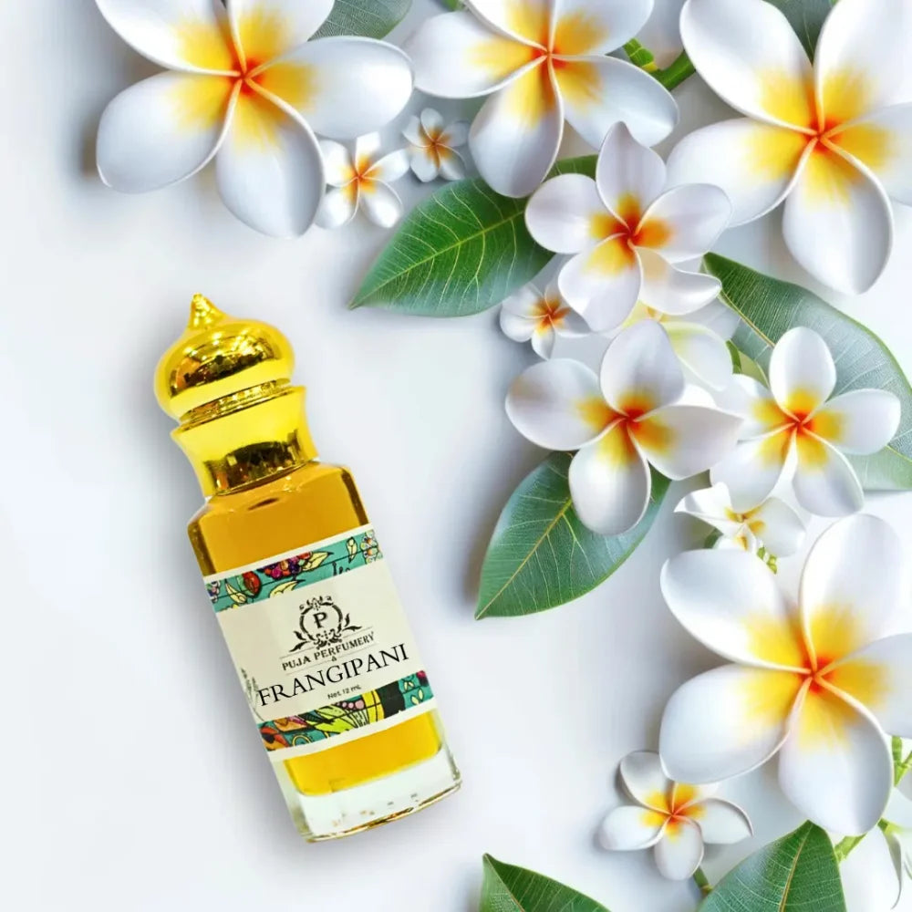 Bottle of Frangipani perfume surrounded by white and yellow flowers on a light background