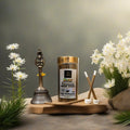 Kesar Chandan incense sticks with a traditional bell and flowers on a wooden board.