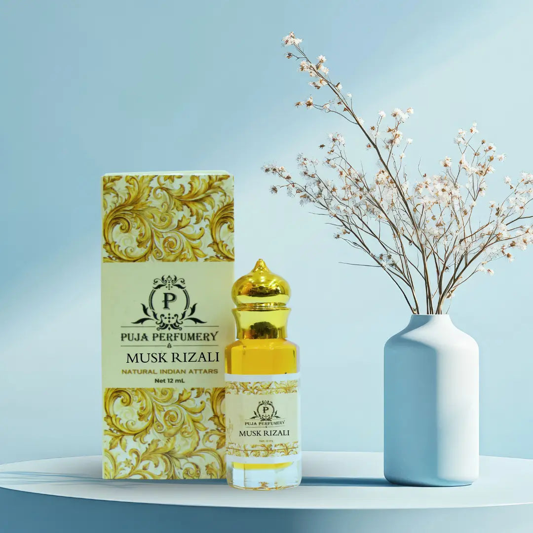 Puja Perfumery Musk Rizali perfume bottle and packaging on a light blue background with a vase of flowers.