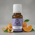 Essential oil bottle with oranges and peel on a gray background
