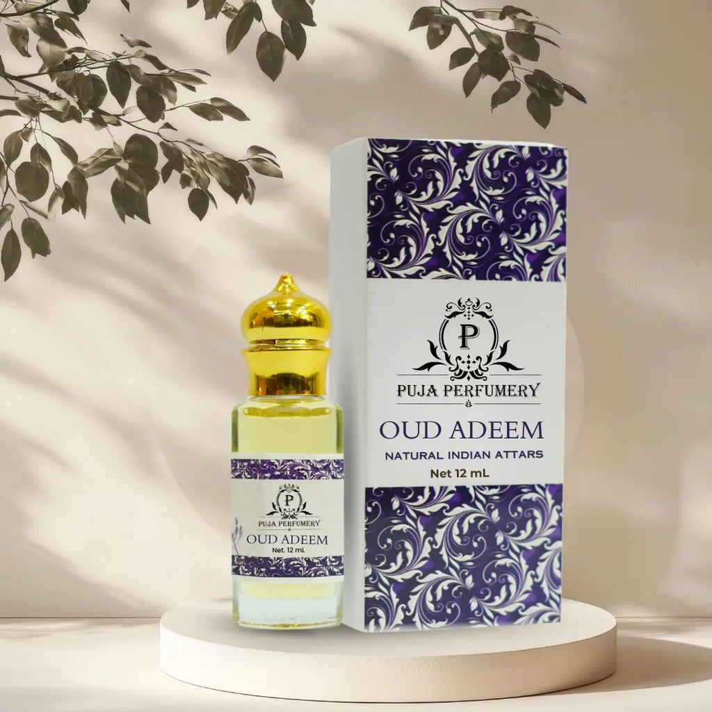 Puja Perfumery Oud Adeem attar bottle and packaging on a neutral background with leaves.