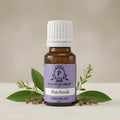 Patchouli essential oil bottle with leaves on a neutral background