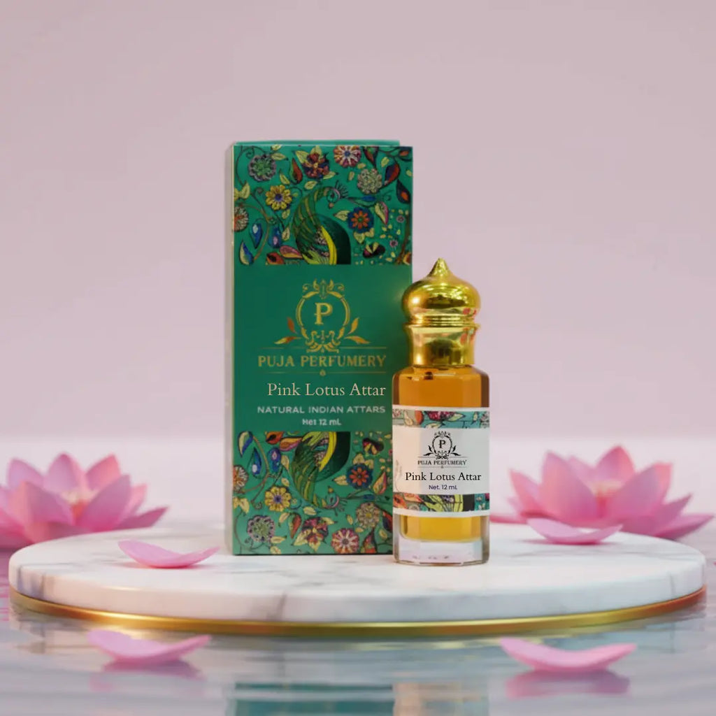 Puja Perfumery Pink Lotus Attar bottle and box with pink lotus flowers on a marble base.