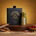 Puja Perfumery Sandali Kesar Attar bottle and packaging on a wooden surface with a warm background