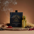 Puja Perfumery Sandalwood Shamama pure oil with packaging on a wooden surface with smoke and incense.