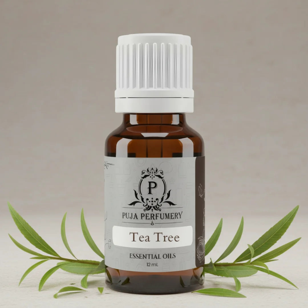 Bottle of Puja Perfumery Tea Tree essential oil with leaves on a neutral background