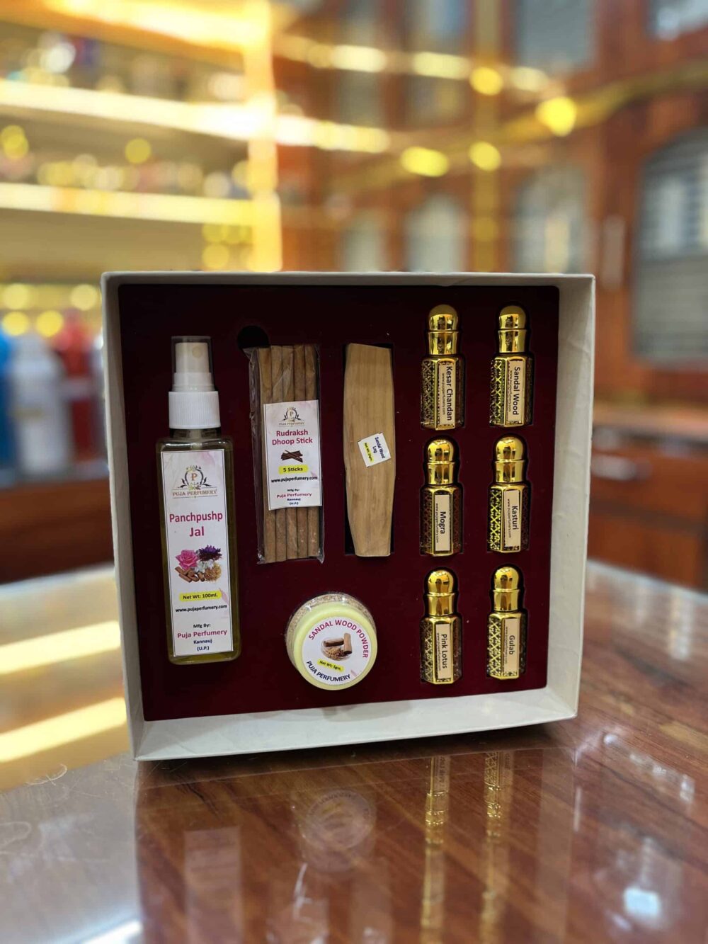 Set of items including bottles and a box on a reflective surface with a blurred background